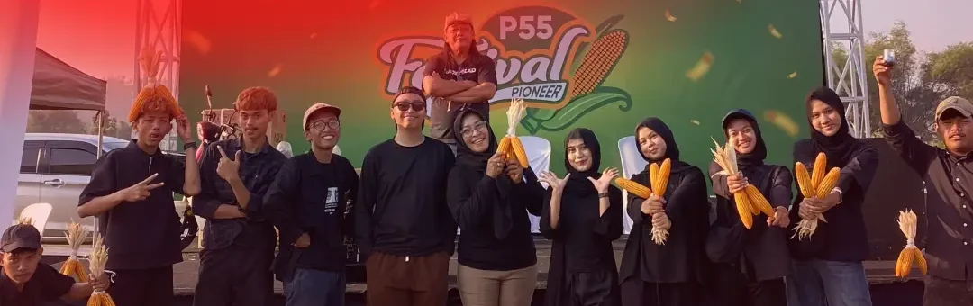 Tim berpakaian hitam berfoto di depan backdrop P55 Festival Pioneer sambil memegang jagung